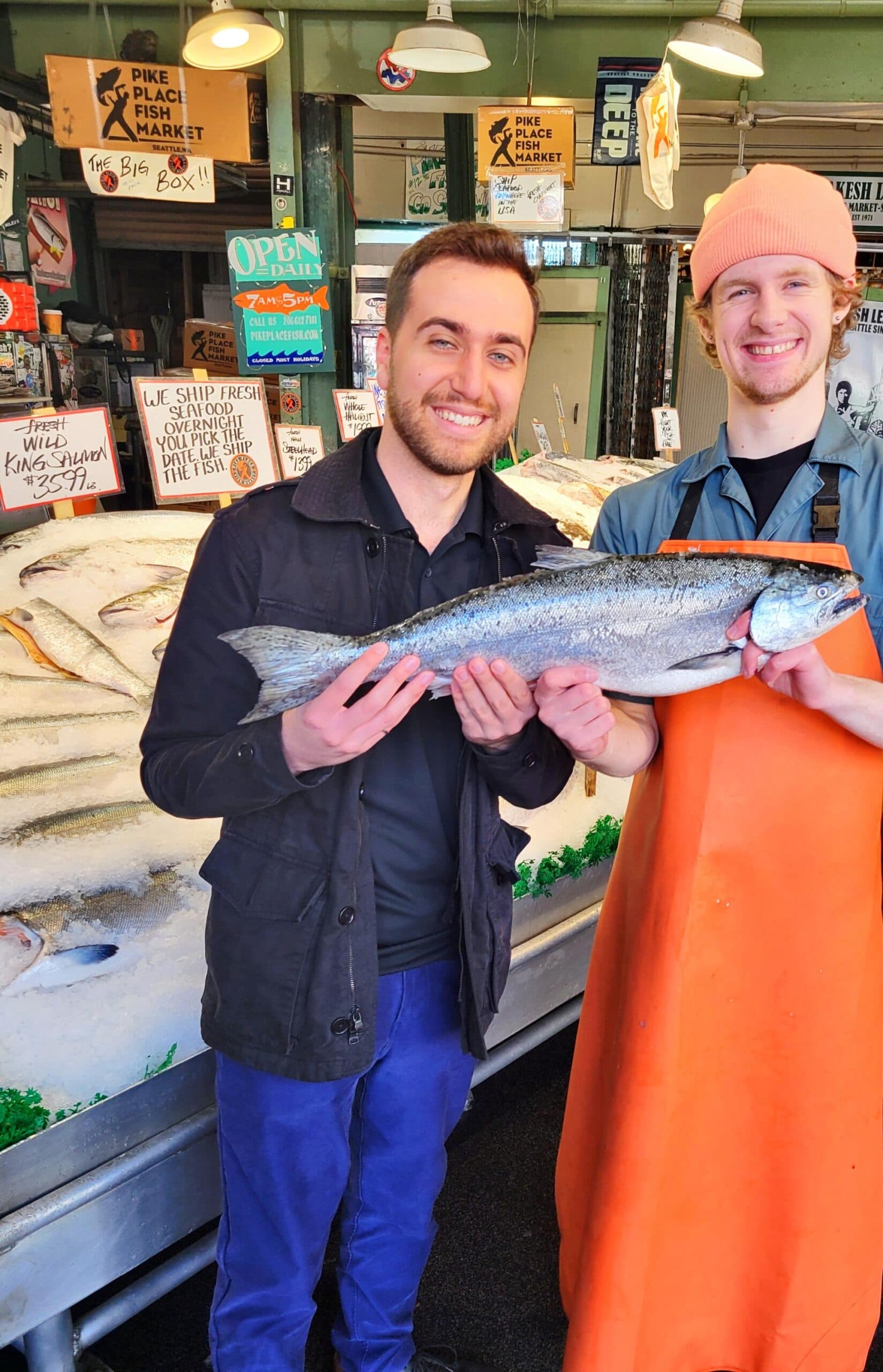 Holding a fresh salmon with a fishmonger at Pike Place Fish Market in Seattle